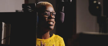 Black female podcaster Black woman speaking in to mic